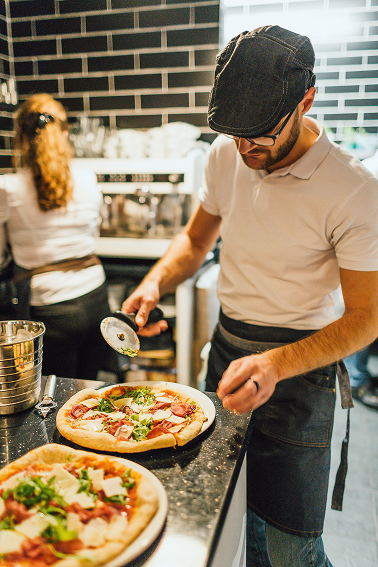 Johnathan Demario preparing pizza at the counter